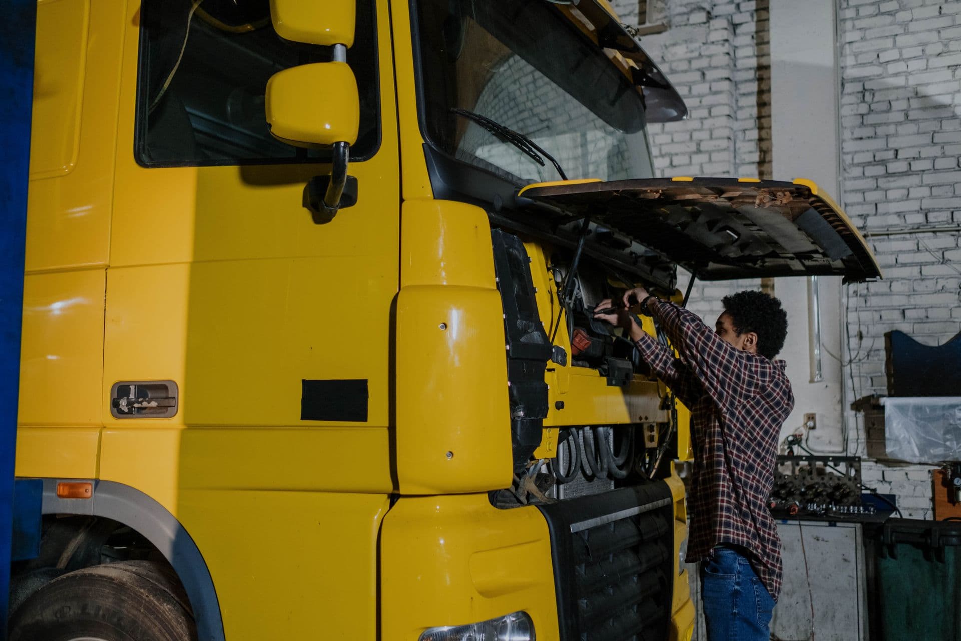 Profissional inspecionando um caminhão pesado em oficina